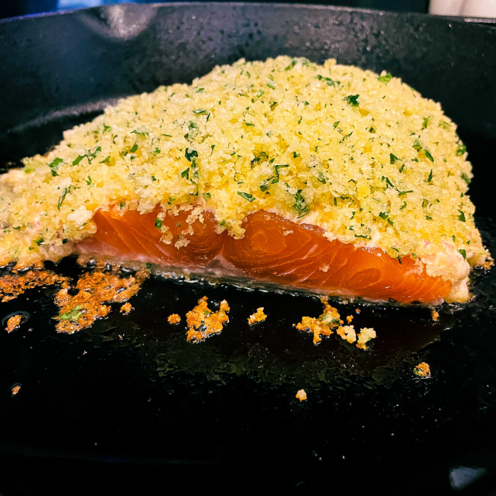 maple dijon panko crusted salmon cooking skin side down in a hot cast iron skillet
