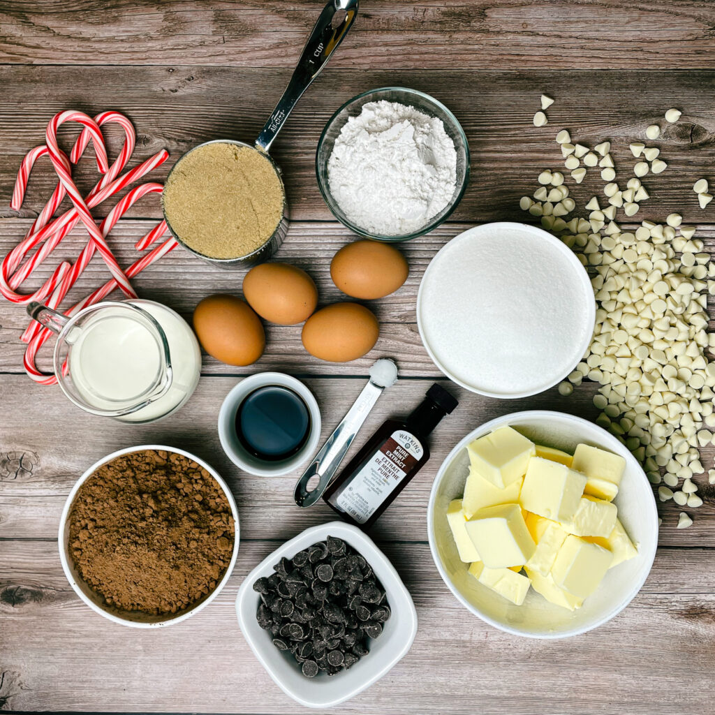 Ingredients for peppermint bark brownies, laid out on a wooden countertop.