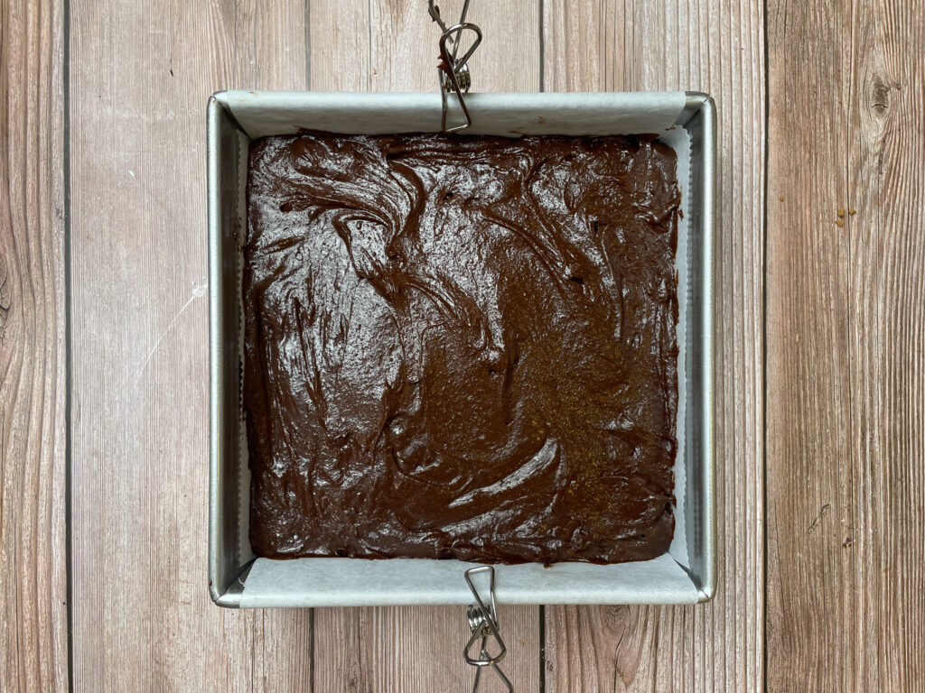 Brownie batter poured in to a prepared baking pan.
