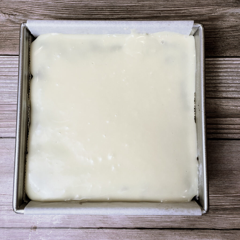 Melted white chocolate spread over the top of baked brownies in am 8x8 metal pan.