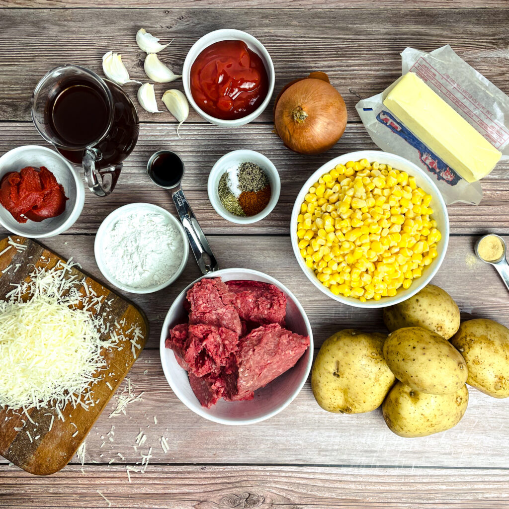 ingredients for shepherd's pie with corn laid out on a wooden table.