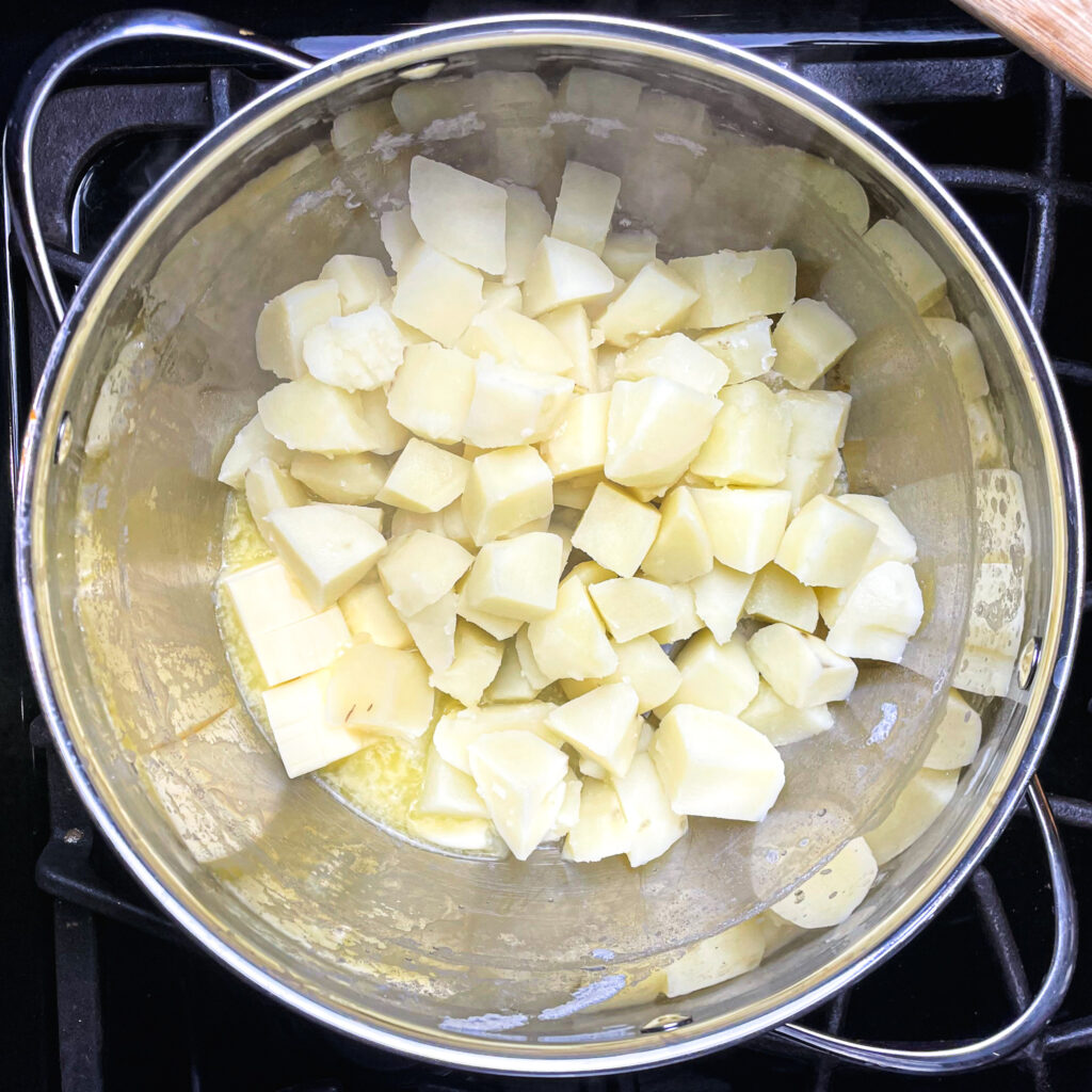 cubed potatoes cooked and drained in a pot