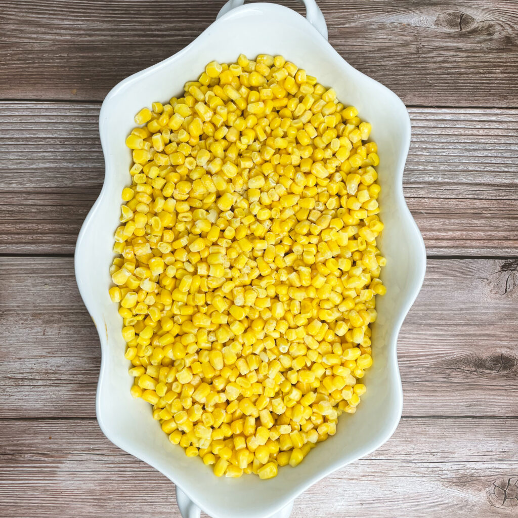 corn layered on top of the beef mixture in a white casserole dish