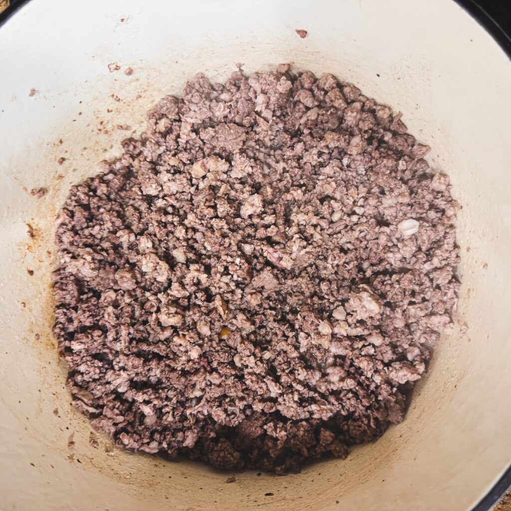Ground beef and pork browning in a large Dutch oven, beginning the base of a one pot bolognese sauce.