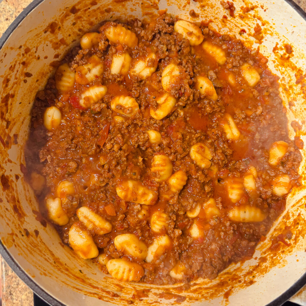 Potato gnocchi added directly to the simmering bolognese sauce in a Dutch oven.