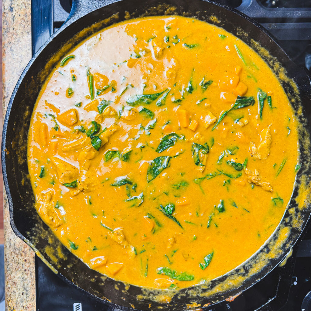 Peanut chicken curry with wilted spinach stirred into the creamy sauce.