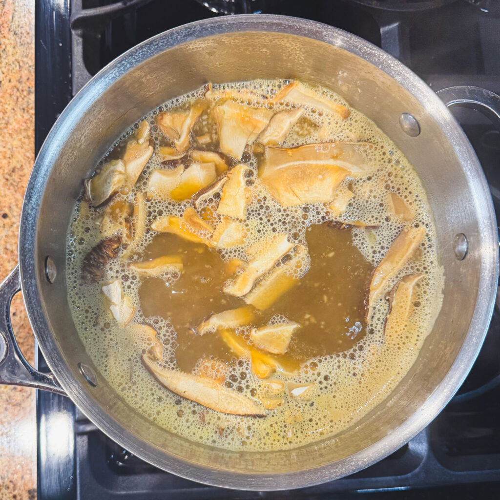 Dried shiitake mushrooms simmering in the ramen broth to deepen flavor.