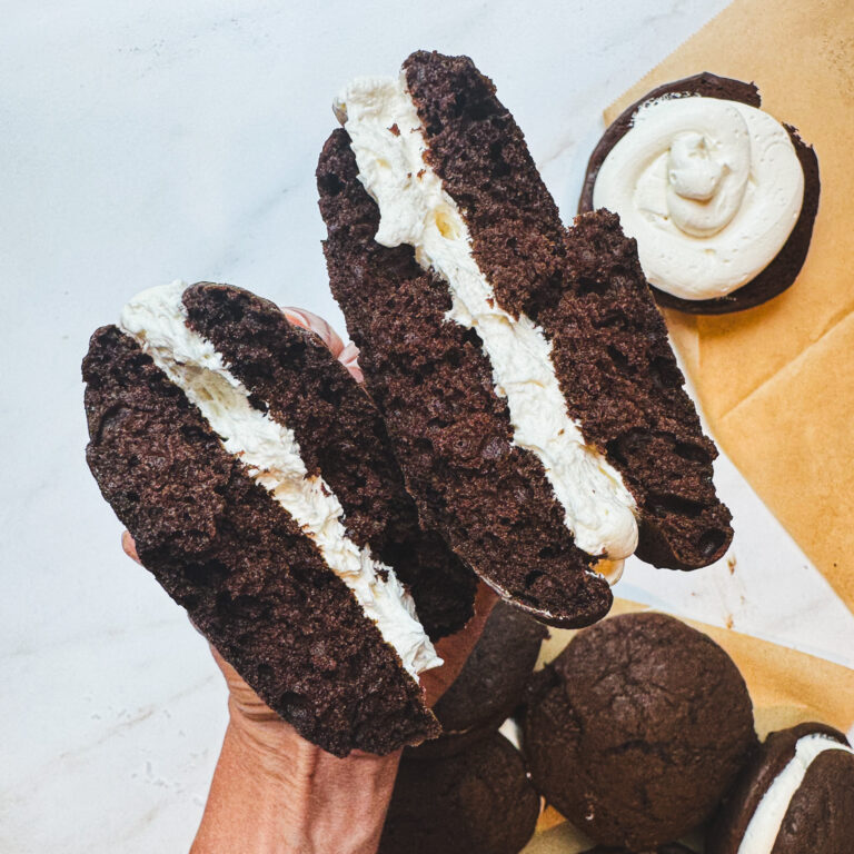 Homemade Maine whoopie pie cut in half showing the soft chocolate cake and fluffy marshmallow filling.