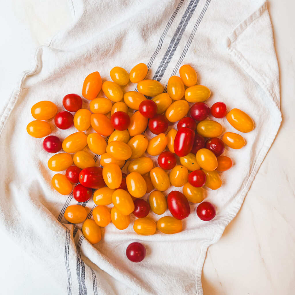 red and yellow grape tomatoes on a a white kitchen towel