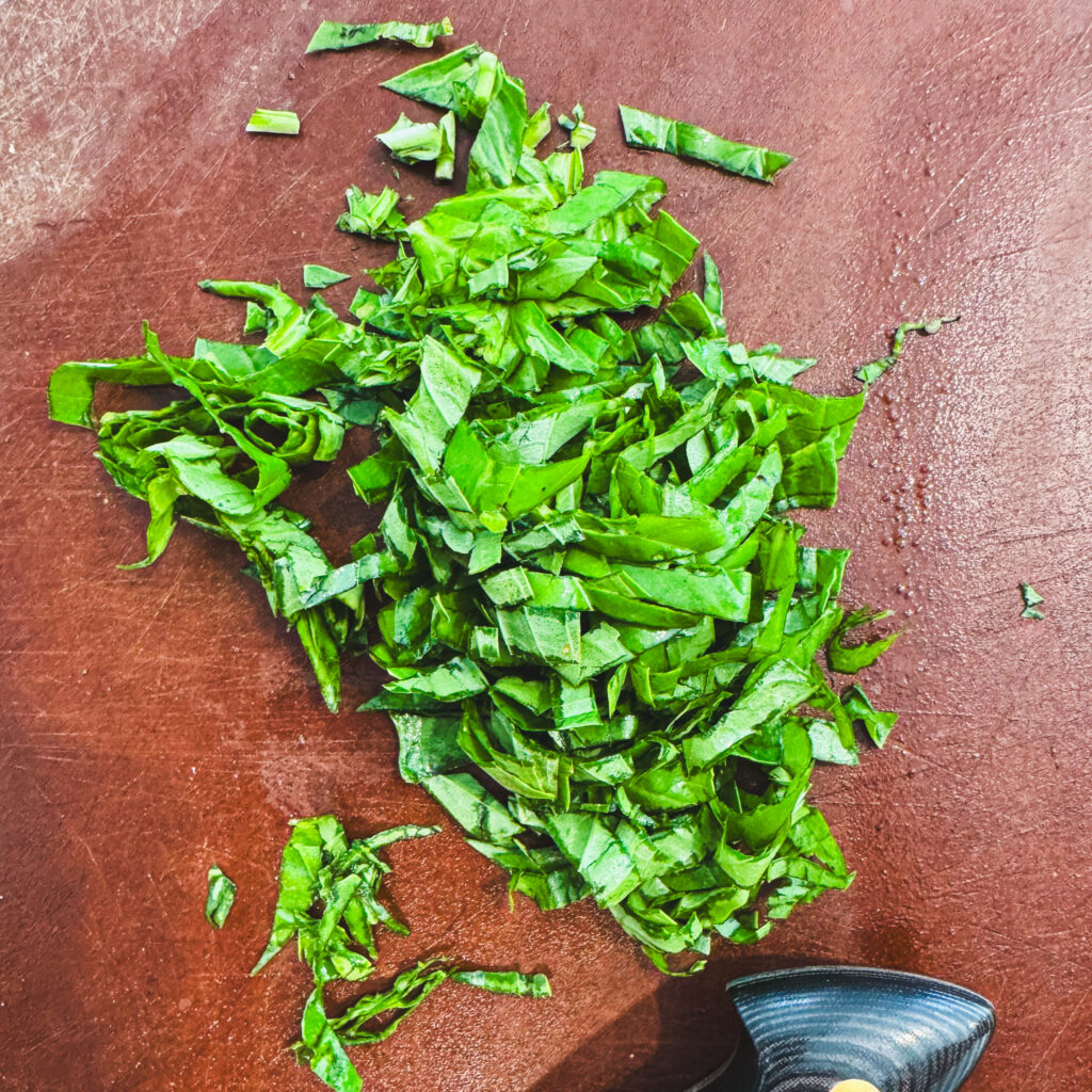 Fresh basil leaves thinly sliced into ribbons for bruschetta.