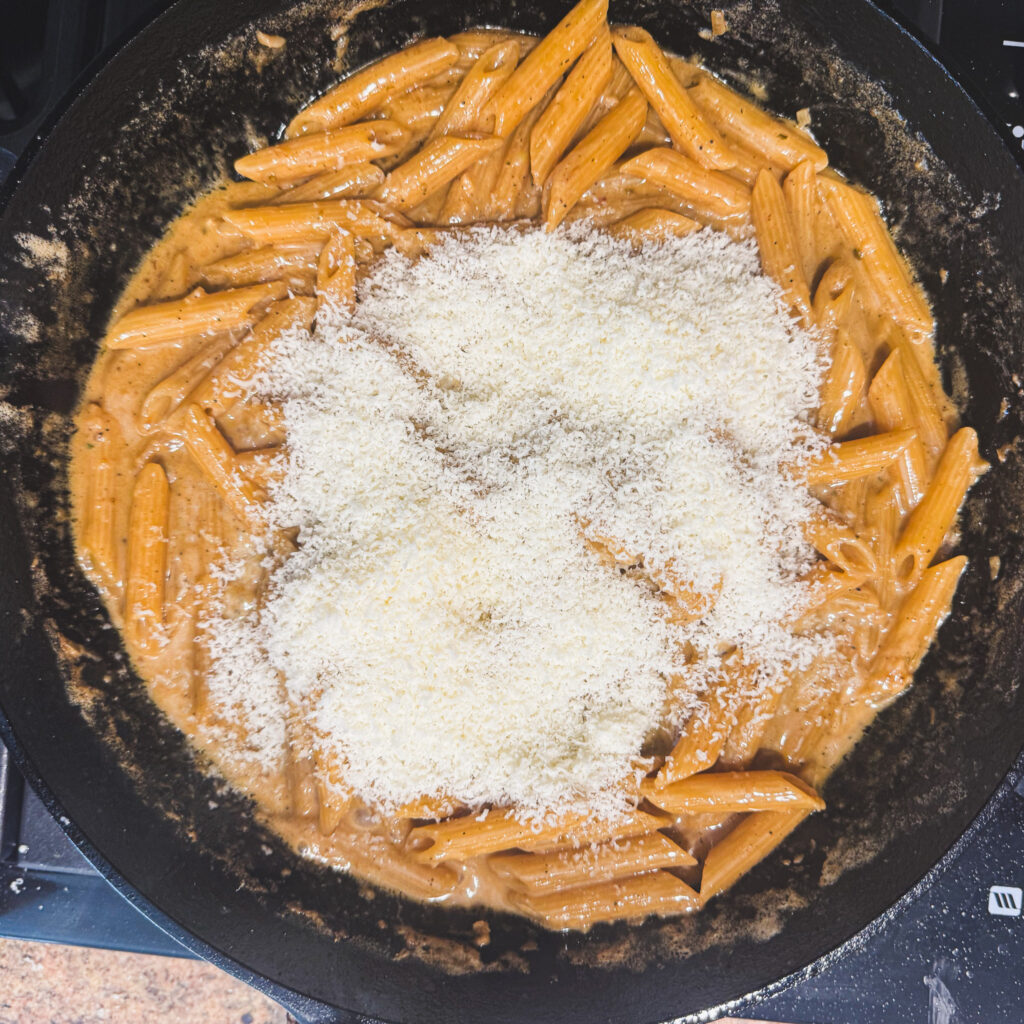 Freshly grated Parmesan cheese added to creamy penne pasta.