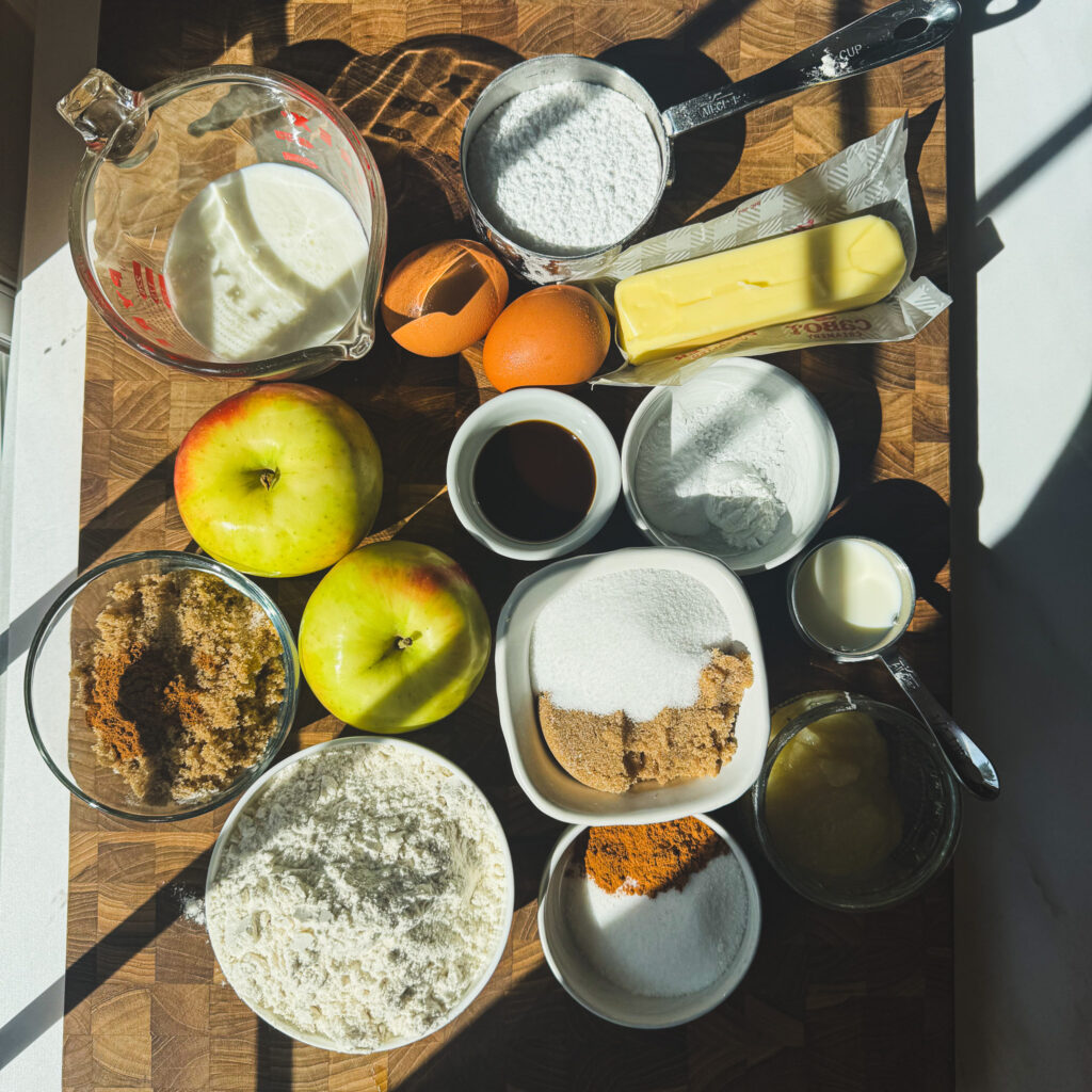 Ingredients for apple fritter skillet cake with fresh apples, brown butter, flour, cinnamon, brown sugar, sour cream and vanilla.