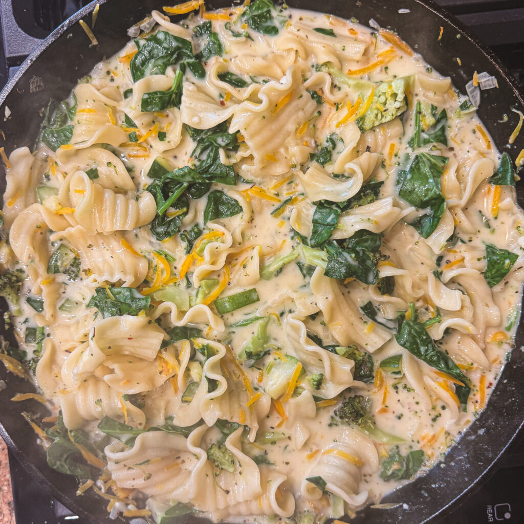 Spinach stirred into creamy white lasagna primavera with vegetables and wide noodles.