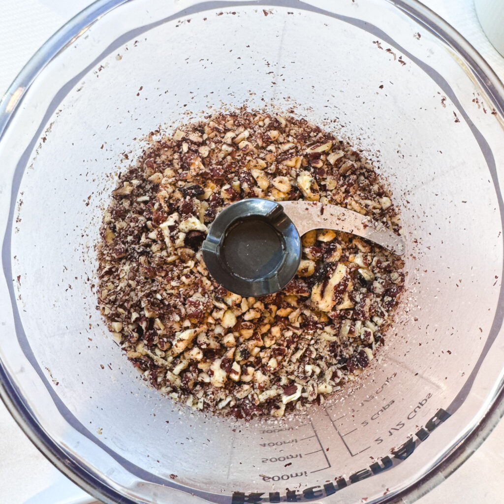 Pecans finely chopped in a food processor for the pecan-crusted chicken coating.
